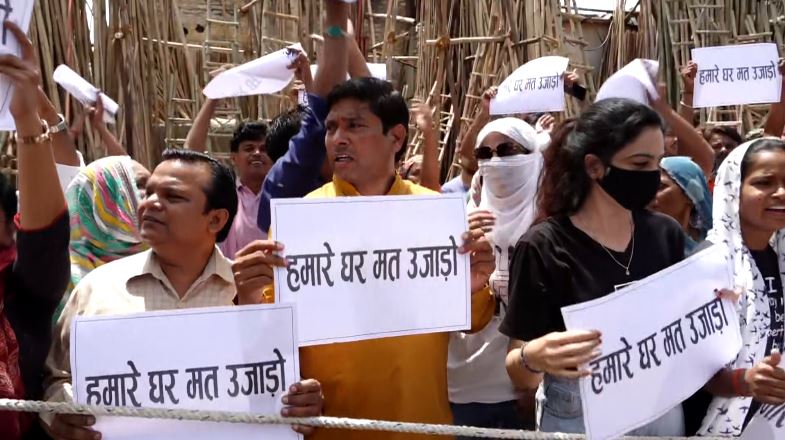 दिल्ली की पूर्व मुख्यमंत्री मंगलवार को कालकाजी में भूमिहीन कैंप के निवासियों के साथ उनके घरों को गिराए जाने से पहले हो रहे विरोध में शामिल हुईं। झुग्गी-झोपड़ी कैंप में घरों पर दिल्ली विकास प्राधिकरण की ओर से बेदखली के नोटिस चिपकाए गए हैं, जिसमें अतिक्रमण करने वालों को तीन दिनों के भीतर जगह छोड़ने या कार्रवाई का सामना करने की चेतावनी दी गई है। एएपी नेता आतिशी, जिनका निर्वाचन क्षेत्र भूमिहीन कैंप से आता है, ने दिल्ली की मुख्यमंत्री रेखा गुप्ता की आलोचना करते हुए कहा कि वो झुग्गी-झोपड़ियों को नहीं गिराने के अपने वादे से मुकर रही हैं। उन्होंने कहा, "दो दिन पहले दिल्ली की सीएम रेखा गुप्ता ने कहा था कि कोई झुग्गी नहीं तोड़ी जाएगी, एक भी घर को नहीं छुआ जाएगा। भूमिहीन कैंप के निवासी जिनके घर कल तोड़े जाएंगे, वे आज शांतिपूर्ण विरोध प्रदर्शन कर रहे थे। वे 'हमारे घर मत उजाड़ो' लिखी तख्तियां लेकर विरोध कर रहे थे। उन पर लाठीचार्ज किया गया और उन्हें तितर-बितर कर दिया गया और हिरासत में ले लिया गया। मैंने कई लोगों से बात की है। उन्हें बस में ले जाया जा रहा है और कोई हमें नहीं बता रहा है कि उन्हें कहां ले जाया जाएगा। एक तरफ आप उनके घर तोड़ते हैं और फिर आप उनकी आवाज उठाने के अधिकार को छीन लेते हैं।" निवासियों का दावा है कि उनके पास 2008 से ही वोटर आईडी, पैन कार्ड, आधार कार्ड है और फिर भी उन्हें कोई वैकल्पिक घर नहीं दिया जा रहा है। मीना ने कहा, "मेरे पास 2008 से ही वोटर आईडी, पैन कार्ड और आधार कार्ड है और बिजली और गैस बिल भी हैं। मैं यहीं पैदा हुई हूं। मुझे घर सिर्फ इसलिए नहीं दिया गया क्योंकि मेरे पास राशन कार्ड नहीं है।" दिल्ली में 40 साल से रह रही सत्यवती ने कहा, "...वो (सीएम) वोट मांगने आईं, रेखा गुप्ता ने हमारा वोट लिया। अगर हमें कानूनी तौर पर वोट देने की अनुमति थी, तो अचानक हमारे घर अवैध कैसे हो गए? 40 साल से मैं यहां रह रही हूं। मेरे पास सभी दस्तावेज हैं। तो मुझे फ्लैट क्यों नहीं दिया गया?"